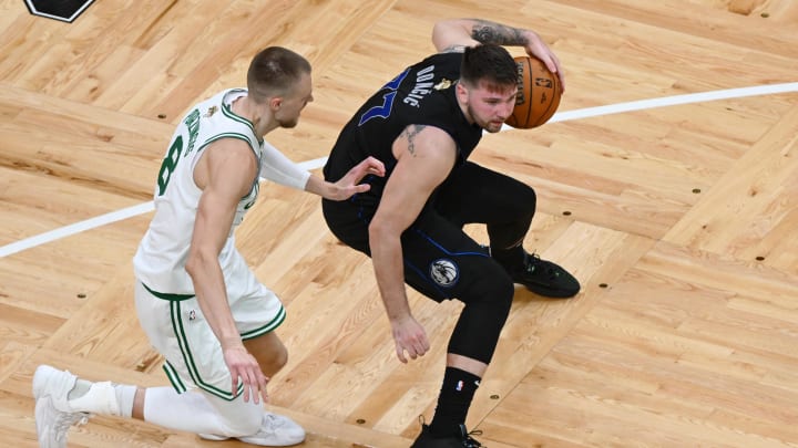 Jun 6, 2024; Boston, Massachusetts, USA; Dallas Mavericks guard Luka Doncic (77) controls the ball against Boston Celtics center Kristaps Porzingis (8) during the third quarter of game one of the 2024 NBA Finals at TD Garden. Mandatory Credit: Peter Casey-USA TODAY Sports