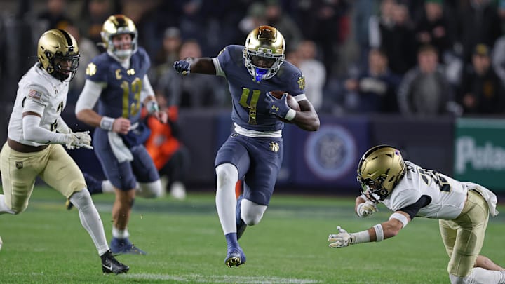Nov 23, 2024; New York, New York, USA; Notre Dame Fighting Irish running back Jeremiyah Love (4) carries the ball as Army Black Knights defensive back Chance Keith (2) pursues at Yankee Stadium. 