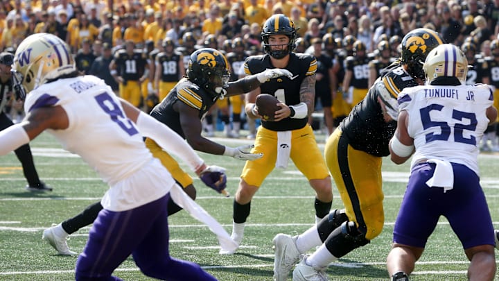 Iowa’s Brendan Sullivan (1) hands the football off to Kaleb Johnson (2) while playing Washington Saturday, Oct. 12, 2024 at Kinnick Stadium in Iowa City, Iowa.