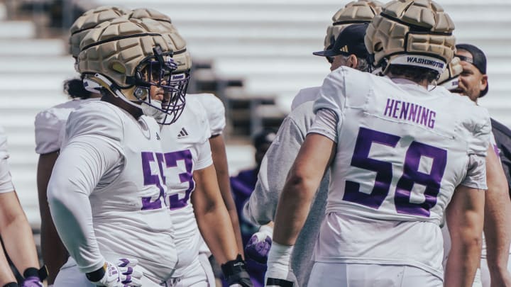 Michael Levelle Watkins and Zach Henning form a UW huddle. 