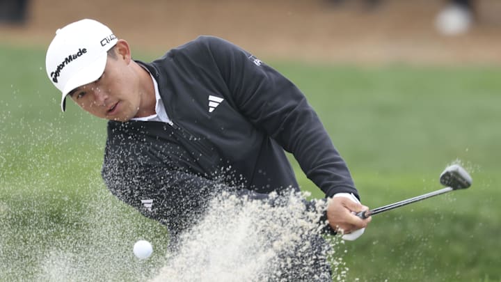 Collin Morikawa hits out of the bunker on the 18th hole and manages a birdie on the final hole Saturday