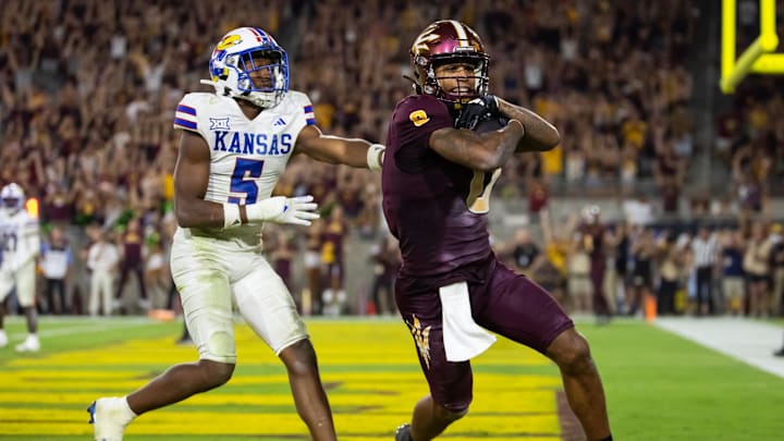 Oct 5, 2024; Tempe, Arizona, USA; Arizona State Sun Devils wide receiver Jordyn Tyson (0) scores a touchdown against Kansas Jayhawks safety O.J. Burroughs (5) in the fourth quarter at Mountain America Stadium. Mandatory Credit: Mark J. Rebilas-Imagn Images
