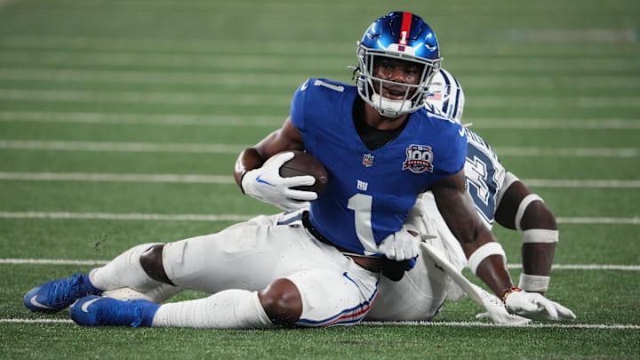Sep 26, 2024; East Rutherford, New Jersey, USA;  New York Giants wide receiver Malik Nabers (1) on a short gain against Dallas Cowboys linebacker DeMarvion Overshown (13) during the first half at MetLife Stadium.  