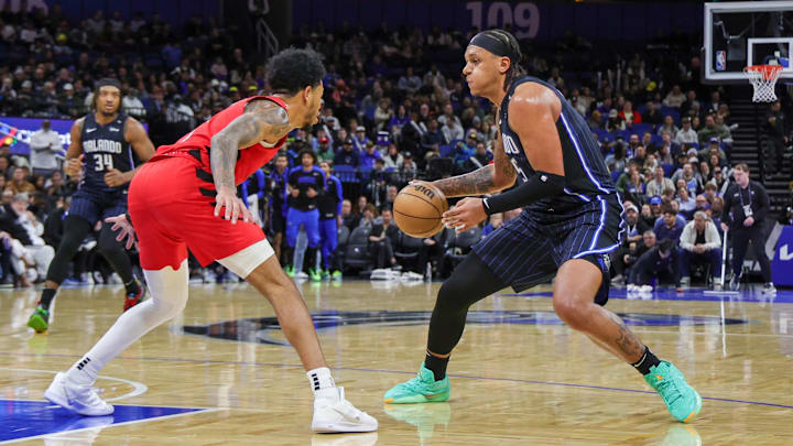 Jan 23, 2025; Orlando, Florida, USA; Orlando Magic forward Paolo Banchero (5) handles the ball in front of Portland Trail Blazers guard Anfernee Simons (1) during the second quarter at Kia Center. Mandatory Credit: Mike Watters-Imagn Images