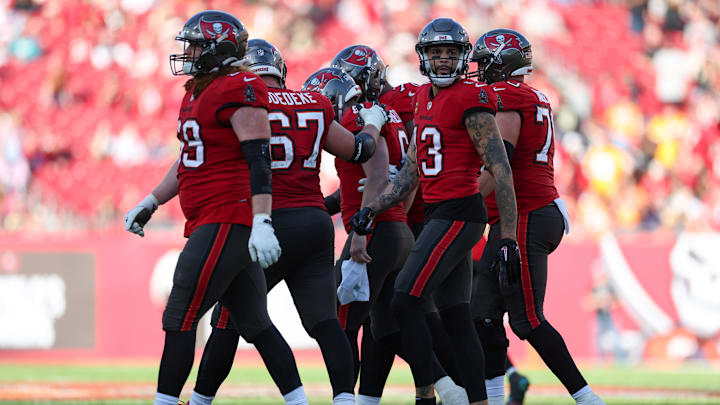Dec 31, 2023; Tampa, Florida, USA;  Tampa Bay Buccaneers quarterback Baker Mayfield (6) is helped off the field by offensive tackle Luke Goedeke (67) against the New Orleans Saints in the fourth quarter at Raymond James Stadium. Mandatory Credit: Nathan Ray Seebeck-Imagn Images