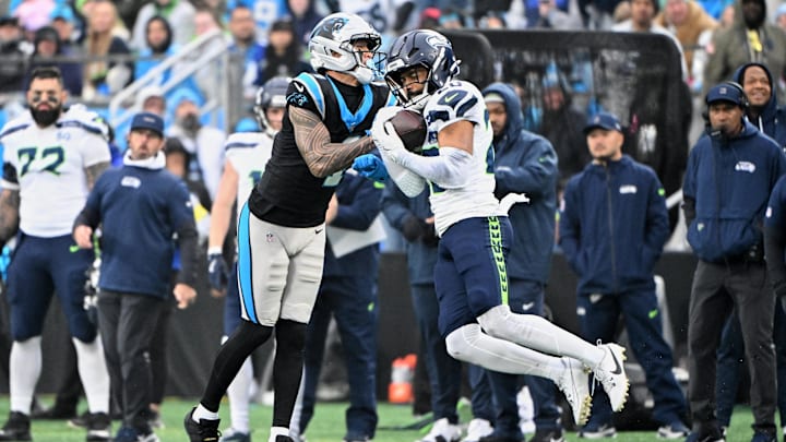 Dec 28, 2025; Charlotte, North Carolina, USA; Seattle Seahawks safety Julian Love (20) intercepts a pass intended for Carolina Panthers wide receiver Tetairoa McMillan (4) during the third quarter at Bank of America Stadium. Mandatory Credit: Bob Donnan-Imagn Images