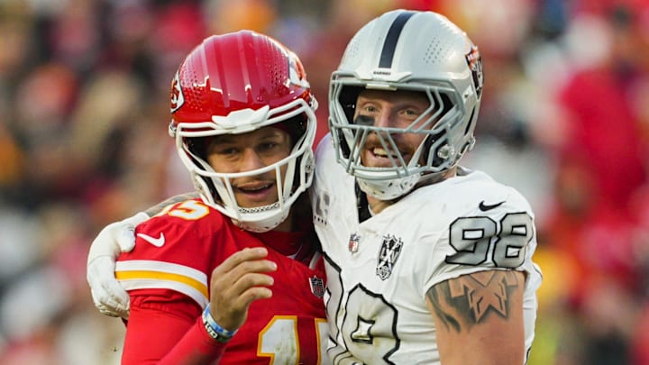 Nov 29, 2024; Kansas City, Missouri, USA; Kansas City Chiefs quarterback Patrick Mahomes (15) and Las Vegas Raiders defensive end Maxx Crosby (98) embrace during the second half at GEHA Field at Arrowhead Stadium. Mandatory Credit: Jay Biggerstaff-Imagn Images