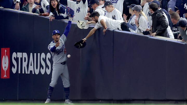 Oct 29, 2024; New York, New York, USA; Los Angeles Dodgers shortstop Mookie Betts (50) reacts after making a catch in foul territory as a New York Yankees fan interferes during the first inning in game four of the 2024 MLB World Series at Yankee Stadium. Mandatory Credit: Brad Penner-Imagn Images