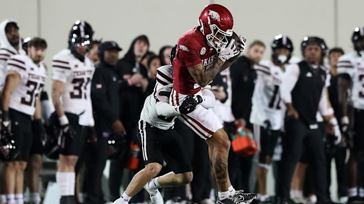 Arkansas Razorback receiver CJ Brown hauls in a catch against Texas Tech's Joseph Plunk during the 2024 AutoZone Liberty Bowl