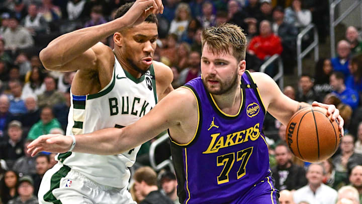 Mar 13, 2025; Milwaukee, Wisconsin, USA;  Los Angeles Lakers guard Luka Doncic (77) drives to the basket against Milwaukee Bucks forward Giannis Antetokounmpo (34) in the third quarter at Fiserv Forum. Mandatory Credit: Benny Sieu-Imagn Images