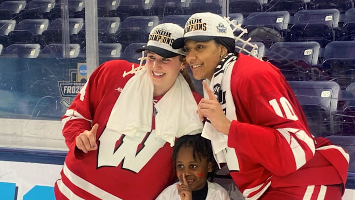 Wisconsin's Caroline Harvey (left) and Laila Edwards pose with Edwards' nephew, Shiloh, after the Badgers defeated Ohio State, 3-2, in NCAA women's hockey championship game at Pegula Ice Arena in University Park, Pa. on March 22, 2026.