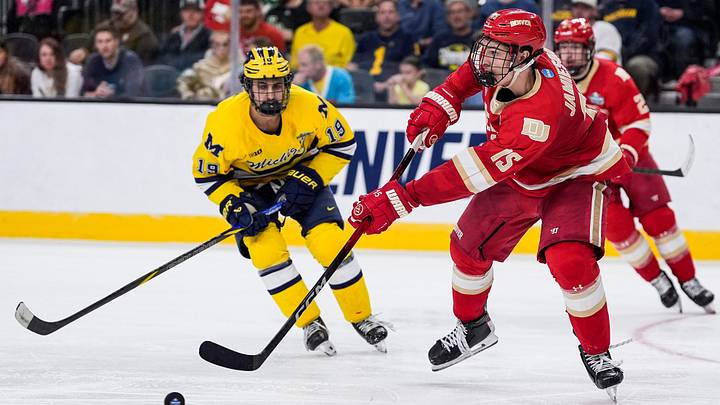 Denver defenseman Eric Jamieson (15) passes the puck against Michigan forward Michael Hage (19) during the third period of the Frozen Four semifinal at T-Mobile Arena in Las Vegas on Thursday, April 9, 2026