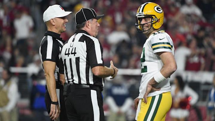 January 16, 2016; Glendale, AZ, USA; Green Bay Packers quarterback Aaron Rodgers (12) talks to NFL referee Clete Blakeman (34, left) and umpire Jeff Rice (44) during the first quarter in a NFC Divisional round playoff game against the Arizona Cardinals at University of Phoenix Stadium. The Cardinals defeated the Packers 26-20 in overtime. Mandatory Credit: Kyle Terada-Imagn Images