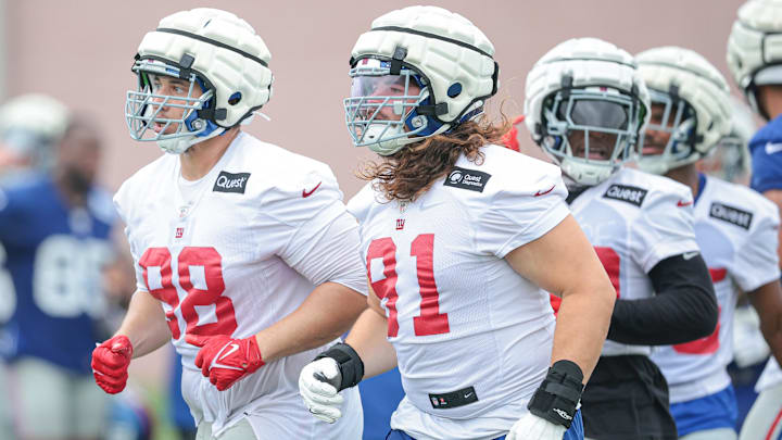 Jul 24, 2024; East Rutherford, NJ, USA; New York Giants defensive tackle D.J. Davidson (98) and defensive tackle Casey Rogers (91) run on the field during training camp at Quest Diagnostics Training Facility.  