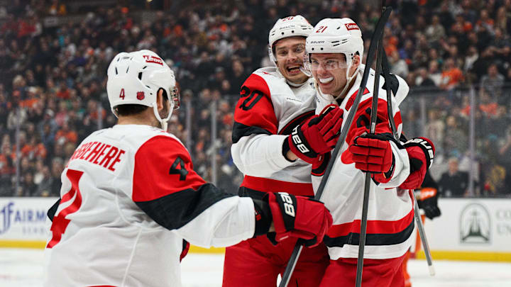 Oct 16, 2025; Anaheim, California, USA; Carolina Hurricanes defenseman Alexander Nikishin (21), right, celebrates with teammates after scoring his first NHL goal during the third period against the Anaheim Ducks at Honda Center. Mandatory Credit: William Liang-Imagn Images