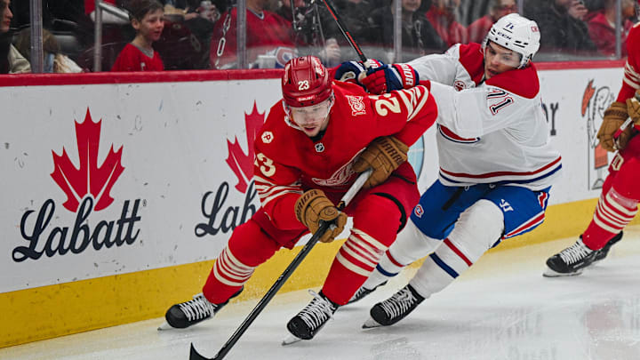 Mar 19, 2026; Detroit, Michigan, USA; Detroit Red Wings left wing Lucas Raymond (23) controls the puck against Montreal Canadiens center Jake Evans (71) during the first period at Little Caesars Arena. Mandatory Credit: Tim Fuller-Imagn Images