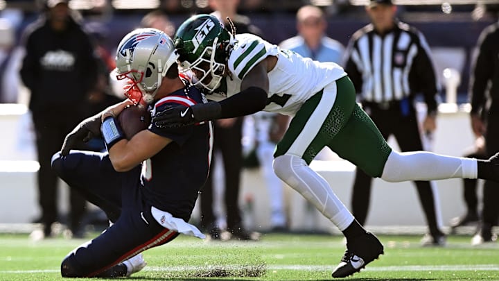Oct 27, 2024; Foxborough, Massachusetts, USA; New England Patriots quarterback Drake Maye (10) is tackled by New York Jets linebacker Jamien Sherwood (44) during the first half at Gillette Stadium.