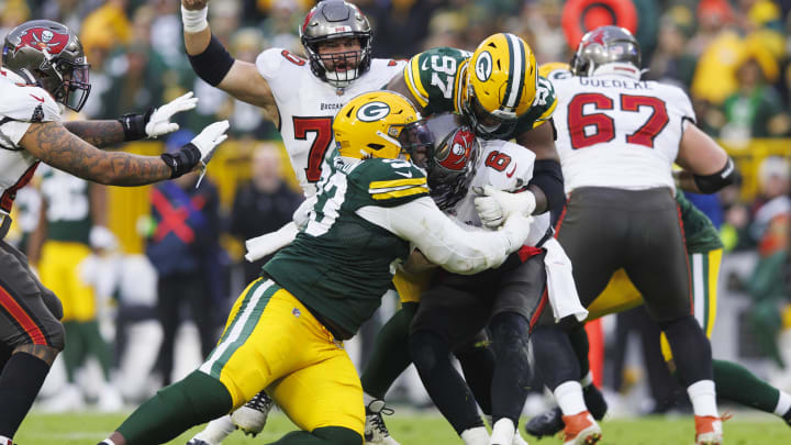 Green Bay Packers defensive lineman Kenny Clark (97) and defensive lineman T.J. Slaton (93) combine to tackle Tampa Bay Buccaneers quarterback Baker Mayfield.
