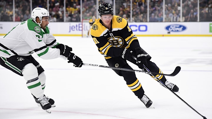 Oct 24, 2024; Boston, Massachusetts, USA;  Boston Bruins center Trent Frederic (11) controls the puck while Dallas Stars defenseman Mathew Dumba (3) defends during the first period at TD Garden. Mandatory Credit: Bob DeChiara-Imagn Images