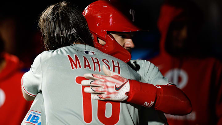  Philadelphia Phillies designated hitter Kyle Schwarber (12) celebrates his solo home run with center fielder Brandon Marsh (16) in the ninth inning against the Colorado Rockies at Coors Field.