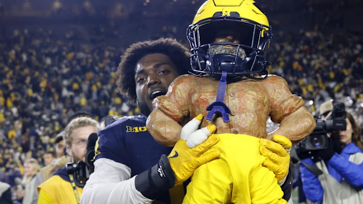 Oct 26, 2024; Ann Arbor, Michigan, USA;  Michigan Wolverines defensive end Josaiah Stewart (0) celebrates with the Paul Bunyan Trophy after defeating the Michigan State Spartans  at Michigan Stadium. Mandatory Credit: Rick Osentoski-Imagn Images