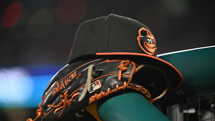 May 8, 2024; Washington, District of Columbia, USA; A Baltimore Orioles hat and glove rest on the dugout rail during a game against the Washington Nationals at Nationals Park. Mandatory Credit: Rafael Suanes-Imagn Images