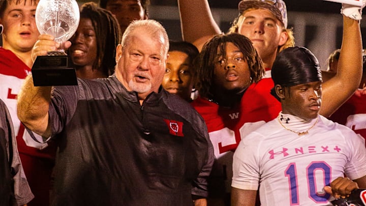 Williston Red Devils head coach Robby Pruitt hoists a glass football into the air after winning his 400th game. The Williston Red Devils hosted Trinity Catholic Celtics at Booster Stadium in Williston, FL on Monday, September 30, 2024. [Doug Engle/Ocala Star Banner]