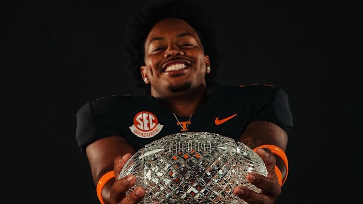 Ethan Utley standing with the Vols national championship trophy.