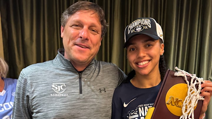 UConn star Azzi Fudd holds the 2025 national championship trophy as the Final Four MVP shares a proud moment with her St. John's College (Washington, DC) coach Jonathan Scribner.