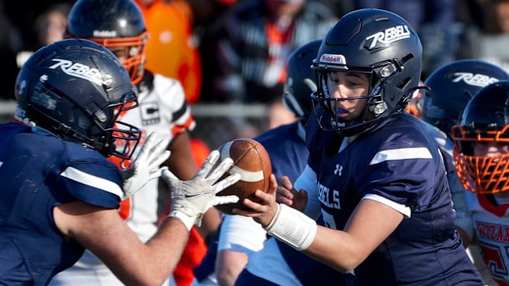 South Kingstown senior Brayden Rosen hands the ball off to his teammate in a game against West Warwick.