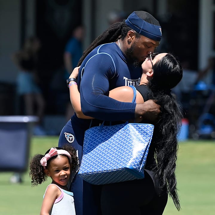 Derrick Henry kisses his girlfriend Adrianna Rivas after running with his daughter Valentina