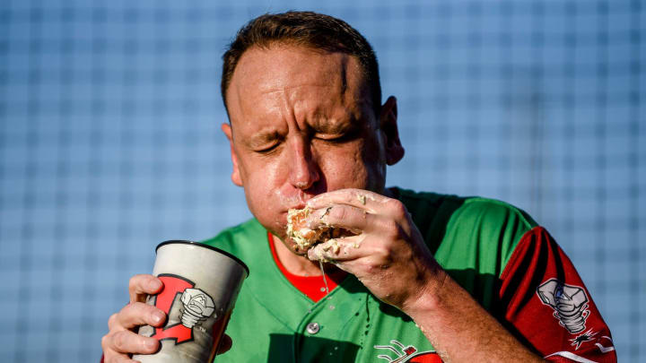 Nathan's Hot Dog Eating champion Joey Chestnut eats an olive burger before the Lugnuts game against the TinCaps in August 2023.