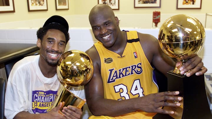 Kobe Bryant (L) of the Los Angeles Lakers holds the NBA Finals trophy