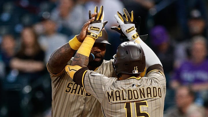 Padres catcher Martin Maldonado (15) celebrates his two run home run with left fielder Jason Heyward (22) in the fifth inning against the Colorado Rockies at Coors Field.