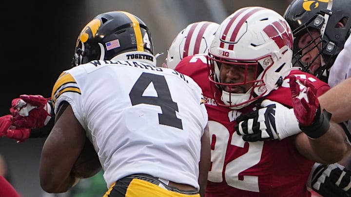 Wisconsin nose tackle Curt Neal (92) tackles Iowa running back Leshon Williams (4) during the first quarter of their game Saturday, October 14, 2023 at Camp Randall Stadium in Madison, Wisconsin.