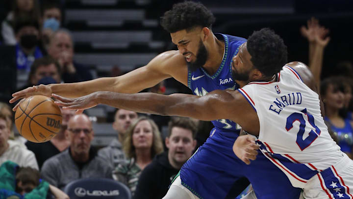 Feb 25, 2022; Minneapolis, Minnesota, USA; Minnesota Timberwolves center Karl-Anthony Towns (32) keeps the ball away from Philadelphia 76ers center Joel Embiid (21) in the first quarter at Target Center. Mandatory Credit: Bruce Kluckhohn-Imagn Images