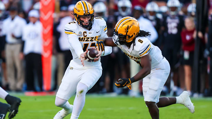 Nov 16, 2024; Columbia, South Carolina, USA; Missouri Tigers quarterback Brady Cook (12) hands off to running back Nate Noel (8) against the South Carolina Gamecocks in the first quarter at Williams-Brice Stadium. Mandatory Credit: Jeff Blake-Imagn Images