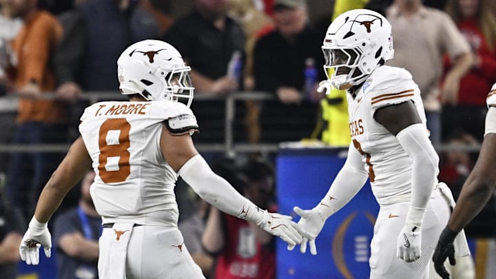 Jan 10, 2025; Arlington, Texas, USA; Texas Longhorns linebacker Trey Moore (8) and linebacker Anthony Hill Jr. (0) celebrate after a sack during the second quarter of the College Football Playoff semifinal against the Ohio State Buckeyes in the Cotton Bowl at AT&T Stadium. Mandatory Credit: Jerome Miron-Imagn Images
