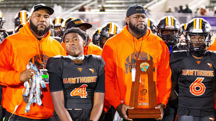 Hawthorne Hornets head coach Cornelius Ingram holds the runner-up trophy after the Hawthorne Hornets played the Madison County Cowboys in the 1R State Championship at The Range at HG Morse Stadium in Sumterville, FL on Friday, December 6, 2024. The Madison County Cowboys defeated the Hawthorne Hornets 21-14. [Doug Engle/Gainesville Sun]