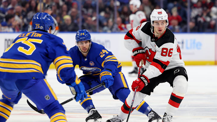 Mar 29, 2024; Buffalo, New York, USA;  New Jersey Devils center Jack Hughes (86) carries the puck up ice as Buffalo Sabres center Dylan Cozens (24) defends during the first period at KeyBank Center. Mandatory Credit: Timothy T. Ludwig-Imagn Images