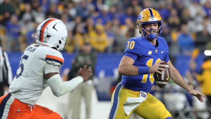 Nov 9, 2024; Pittsburgh, Pennsylvania, USA;  Pittsburgh Panthers quarterback Eli Holstein (10) scrambles with the ball as Virginia Cavaliers linebacker Kam Robinson (5) chases during the second quarter at Acrisure Stadium. Mandatory Credit: Charles LeClaire-Imagn Images