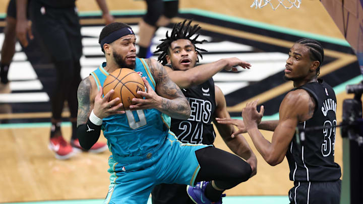 Mar 9, 2024; Charlotte, North Carolina, USA;  Charlotte Hornets forward Miles Bridges (0) grabs the rebound against Brooklyn Nets guard Cam Thomas (24) during the fourth quarter at Spectrum Center. Mandatory Credit: Cory Knowlton-Imagn Images