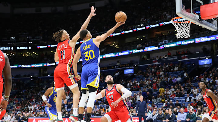 Golden State Warriors guard Stephen Curry (30) drives to the basket against New Orleans Pelicans guard Dyson Daniels (11) and center Jonas Valanciunas (17) at Smoothie King Center. 