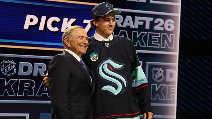 Jun 26, 2026; Buffalo, New York, USA; Chase Reid reacts beside NHL commissioner Gary Bettman after being selected with the seventh pick in the first round of the 2026 NHL Draft by the Seattle Kraken at KeyBank Center. Mandatory Credit: Timothy T. Ludwig-Imagn Images