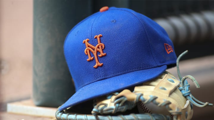 Jul 13, 2022; Atlanta, Georgia, USA; A detailed view of a New York Mets hat and glove in the dugout against the Atlanta Braves in the eighth inning at Truist Park. Mandatory Credit: Brett Davis-Imagn Images