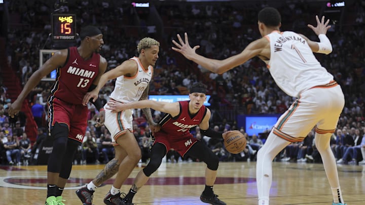 Feb 7, 2024; Miami, Florida, USA; Miami Heat guard Tyler Herro (14) protects the basketball from San Antonio Spurs forward Jeremy Sochan (10) and center Victor Wembanyama (1) during the second quarter at Kaseya Center. Mandatory Credit: Sam Navarro-Imagn Images