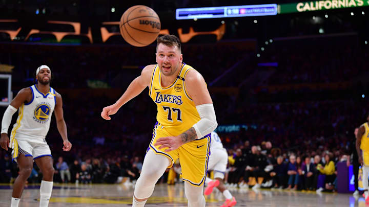 Apr 3, 2025; Los Angeles, California, USA: Los Angeles Lakers guard Luka Doncic (77) plays for the ball against the Golden State Warriors during the second half at Crypto.com Arena. Mandatory Credit: Gary A. Vasquez-Imagn Images