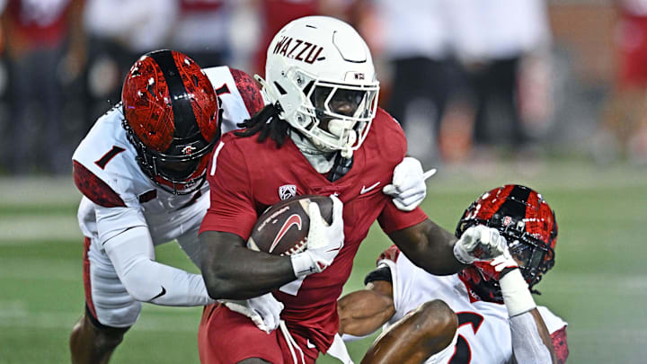Sep 6, 2025; Pullman, Washington, USA; Washington State Cougars running back Angel Johnson (1) is tackled by San Diego State Aztecs safety Eric Butler (6) in the first half at Gesa Field at Martin Stadium. 