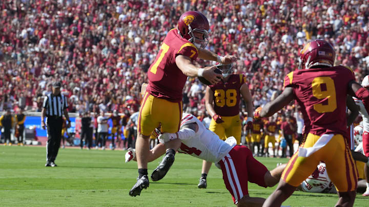 Sep 28, 2024; Los Angeles, California, USA; Southern California Trojans quarterback Miller Moss (7) scores on a 7-yard touchdown run in the fourth quarter against Wisconsin Badgers safety Preston Zachman (14) at United Airlines Field at Los Angeles Memorial Coliseum. Mandatory Credit: Kirby Lee-Imagn Images