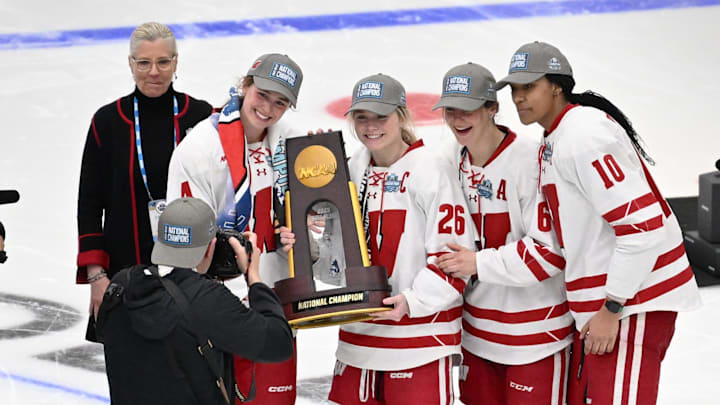 Wisconsin captains, from left, Caroline Harvey and Casey O'Brien and assistant captains Lacey Eden and Laila Edwards pose for photos with the national championship trophy after Wisconsin's 4-3 victory over Ohio State in the NCAA women's hockey Frozen Four title game Sunday, March 23, 2025, at Ridder Arena in Minneapolis, Minnesota.